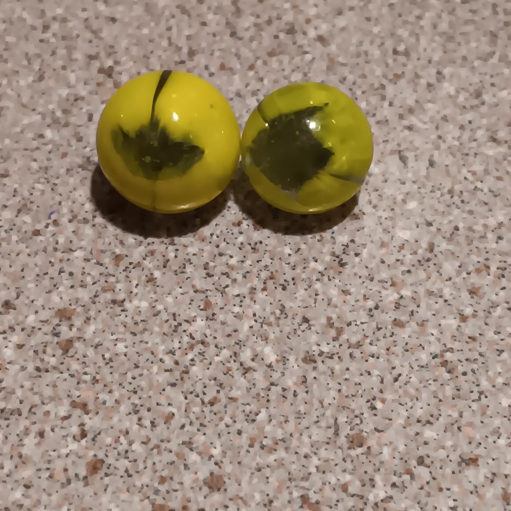 2 very petite marbles  cat eye look,can see thru centre- pupil, otherwise yellow